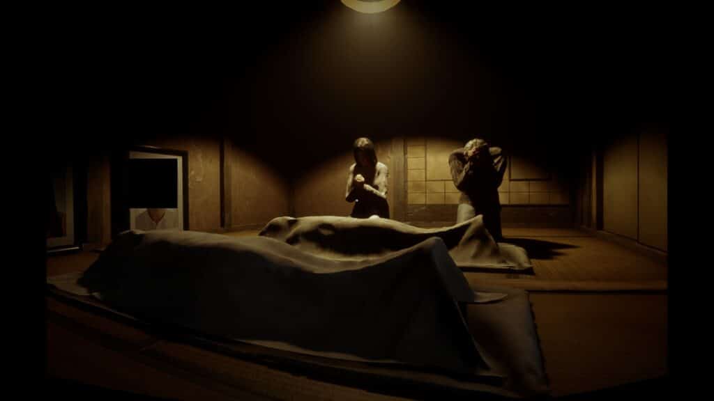 A man and a woman pray over two bodies wrapped in sheets