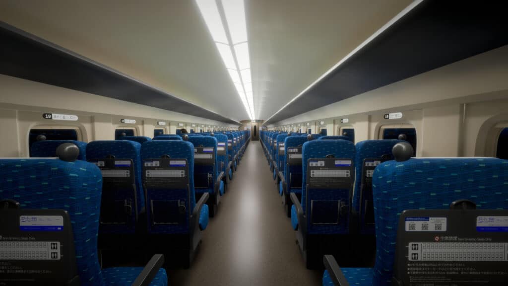 A long hallway of a Shinkansen, blue chairs on either side and bright lights above